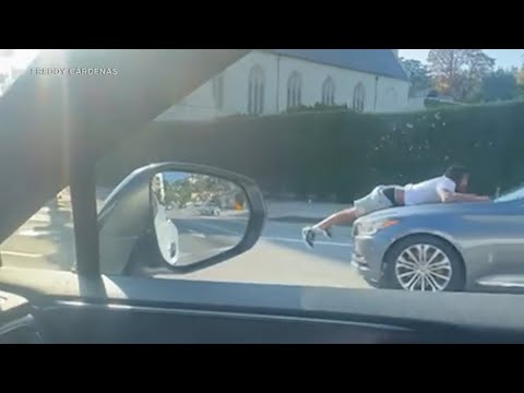 Video: Bizarre video shows man clinging to hood of moving car in Hollywood