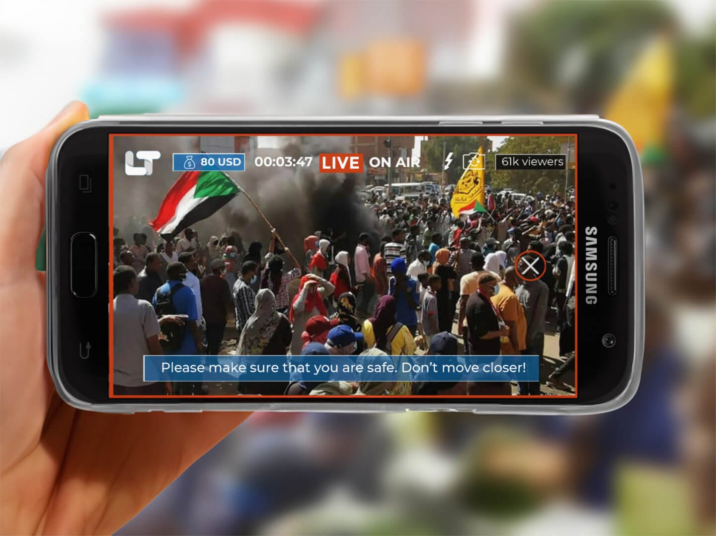 Eine Hand, die ein Smartphone hält, zeigt die LIVETUBE-App an, die einen Live-Stream einer überfüllten Protestszene mit Fahnen und Rauch im Hintergrund zeigt. Eine Sicherheitsmeldung lautet: